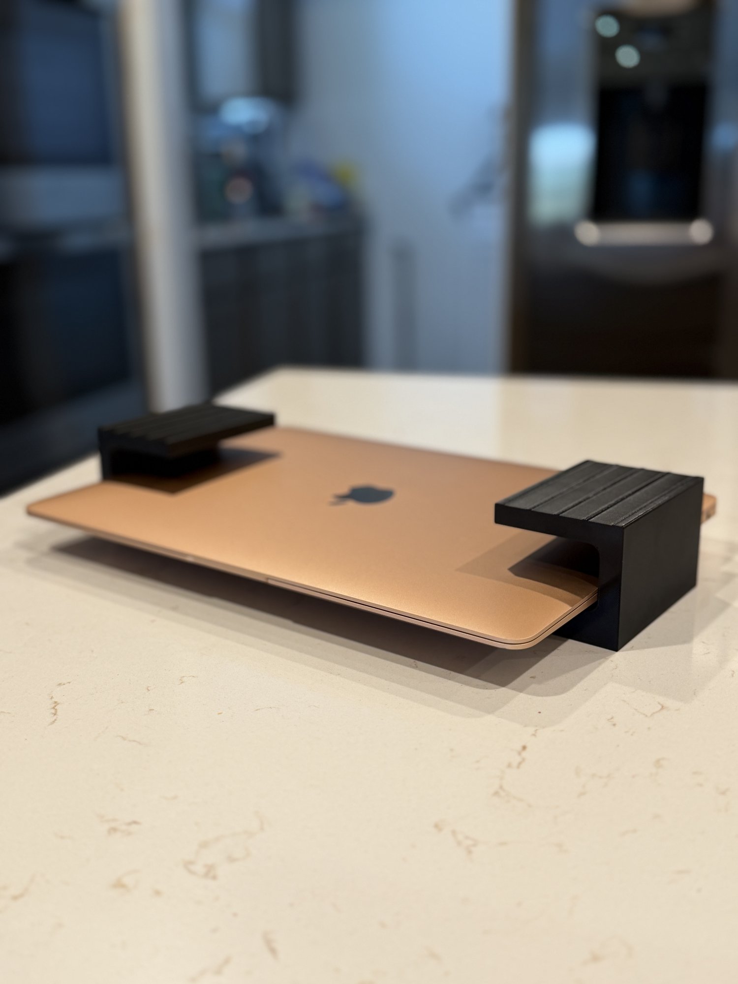 The same black PETG under-desk laptop mount, side view showing its depth, screw holes, and visible print layer lines.
